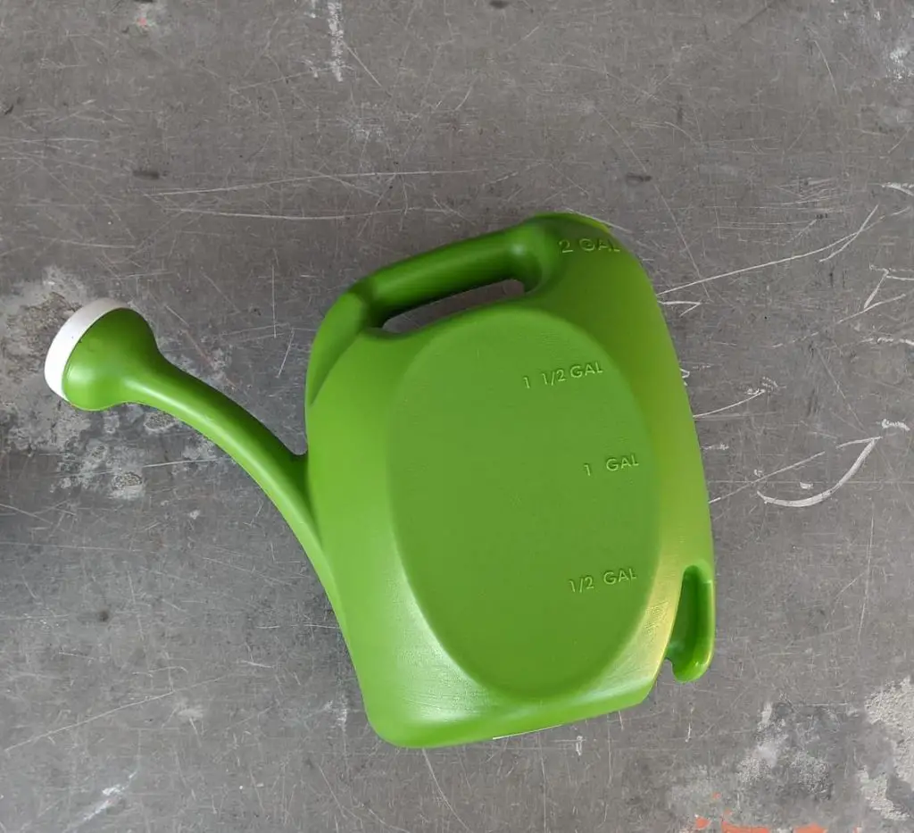green watering can on metal background